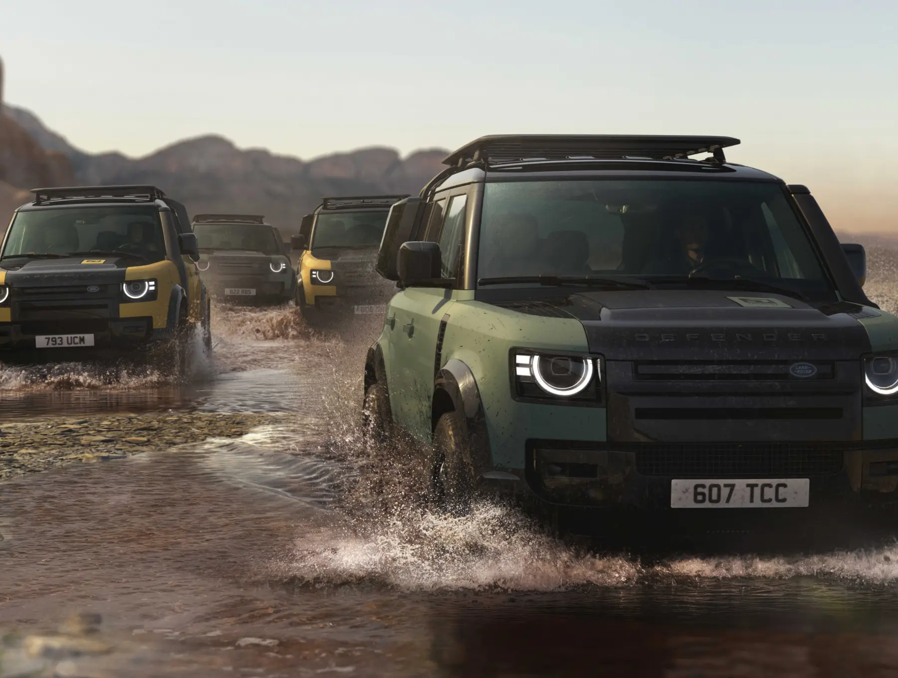Defender Trophy vehicles cross a rugged waterway during an off-road expedition, showcasing capability, exploration and adventure competition performance.
