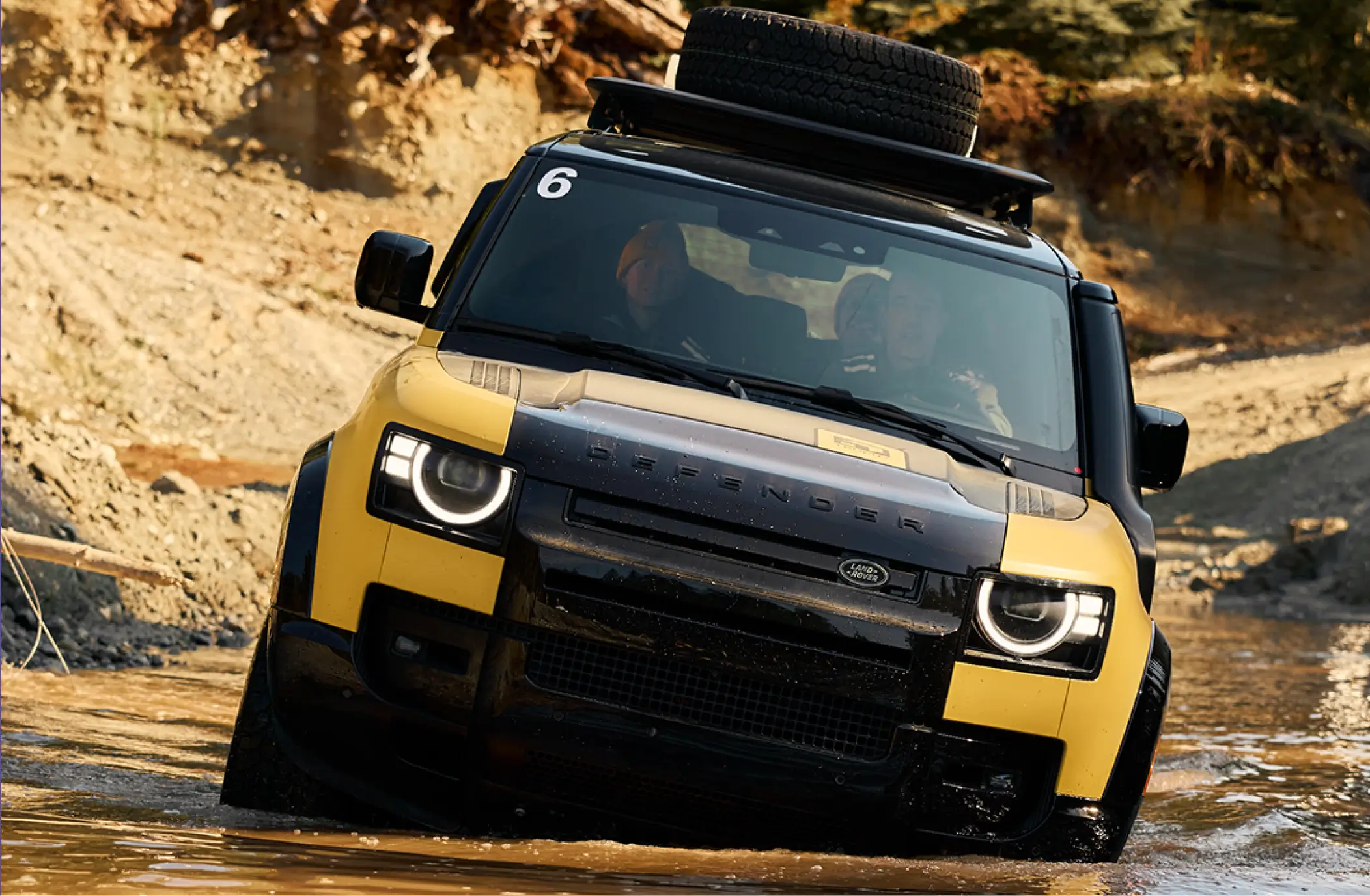 Defender Trophy competitor drives through a water obstacle as judges assess vehicle handling, technical skill and challenge performance.