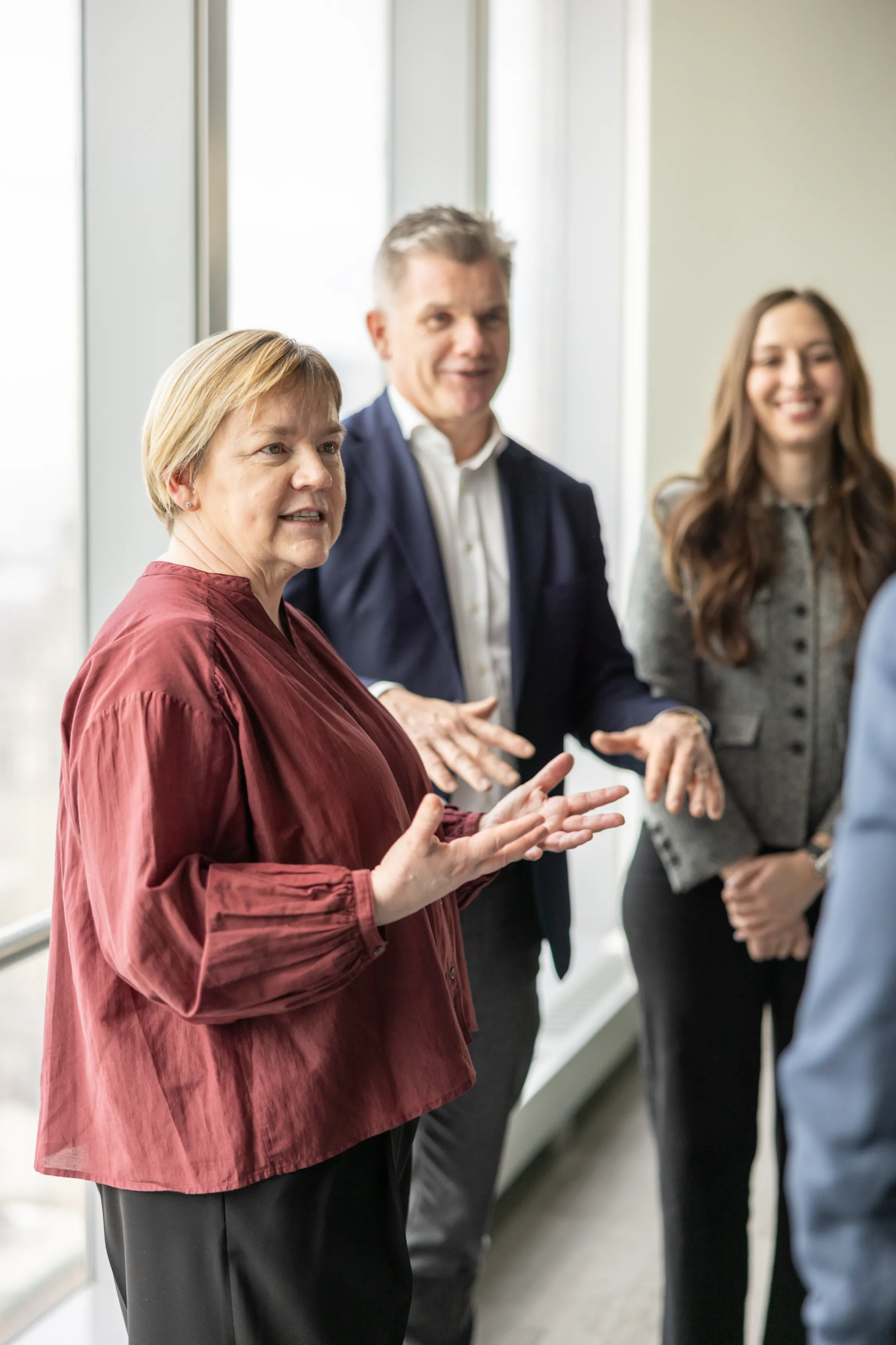 A group of people walking across a walkway in front of a building.