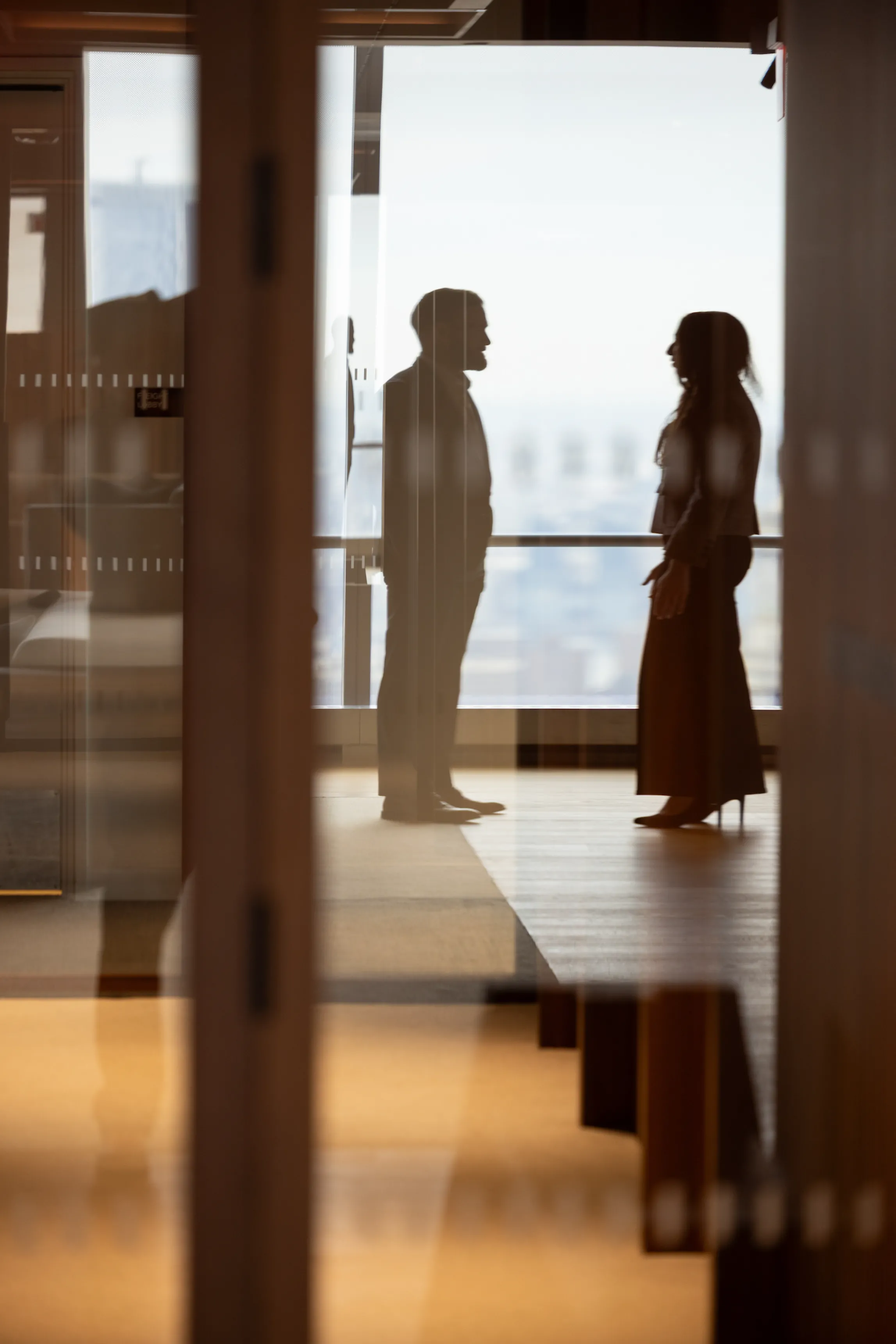 A couple of people sitting at a table with a tablet.