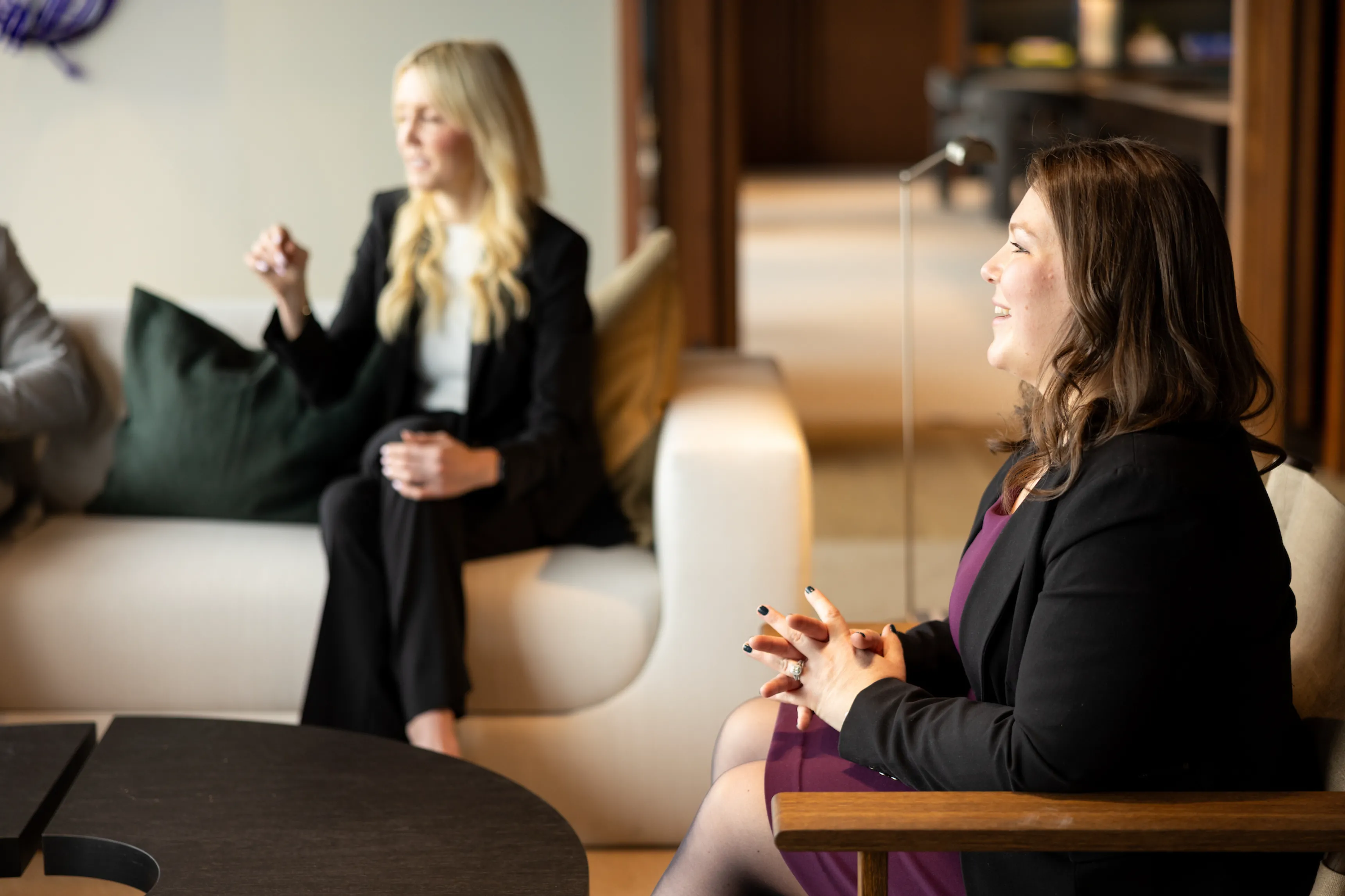 A man in a suit sitting at a table with a laptop.
