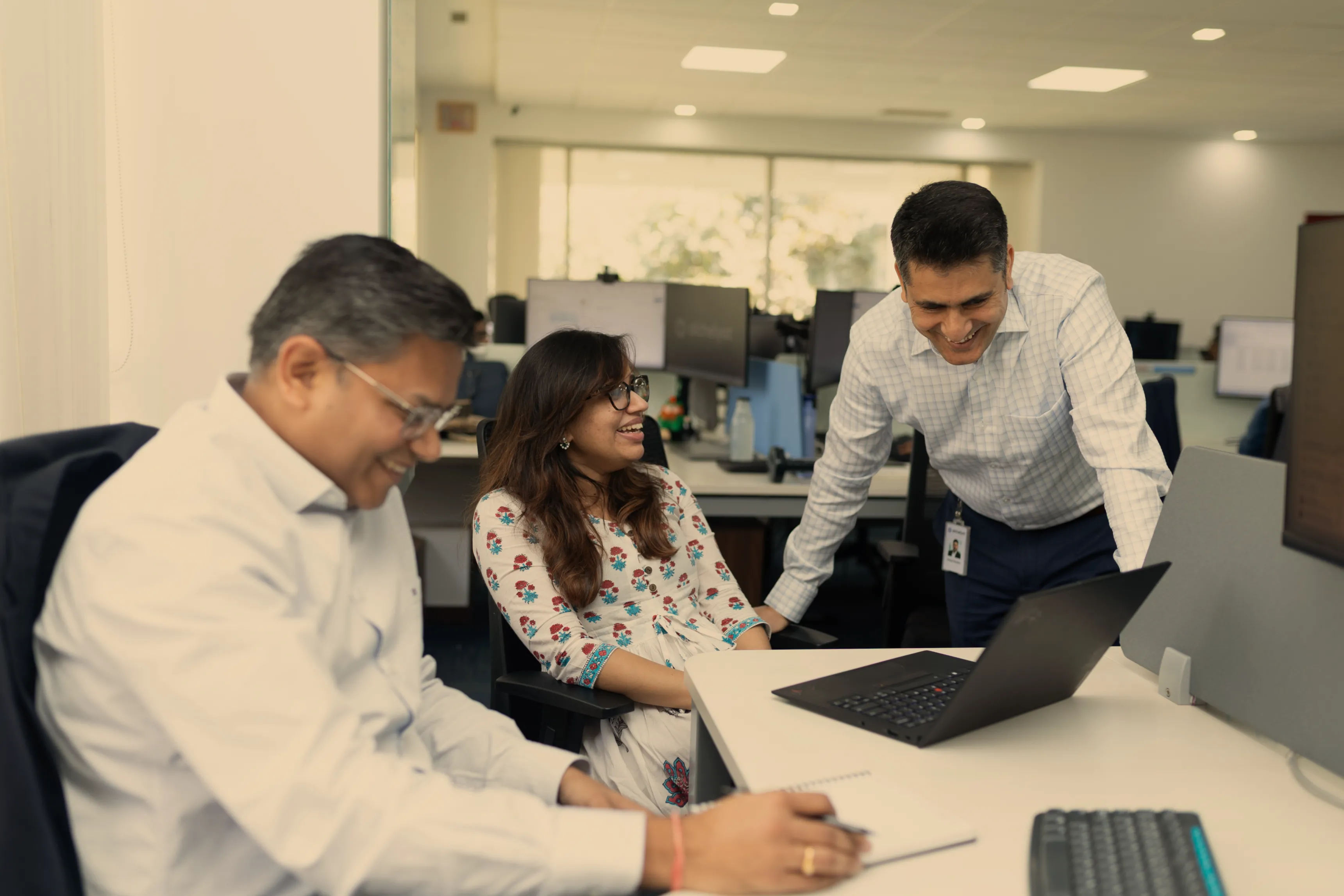 A woman sitting at a table using a laptop computer.