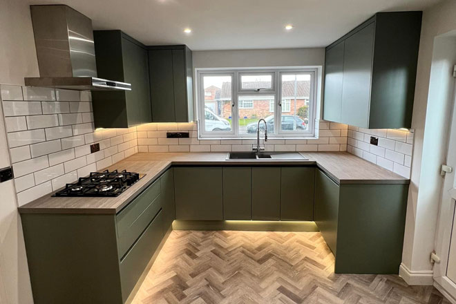 Kitchen design and fitting with green cabinets and under cabinet lighting in Somerset