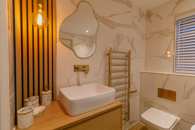 Bathroom design with heated towel rail and feature wall
