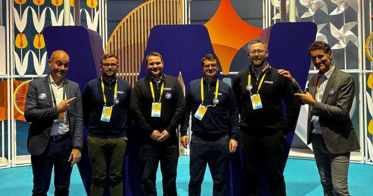 Six members of the IntSys Solutions and HR Path teams at a Workday event, in front of a Workday-branded stand.