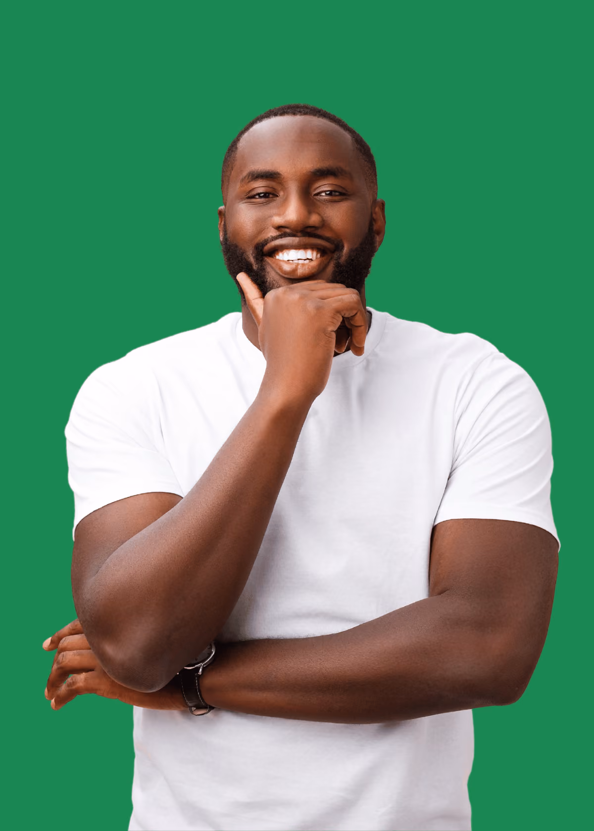 Smiling Black man wearing a white t-shirt with one hand on his chin and the other arm crossed, standing against a solid green background.
