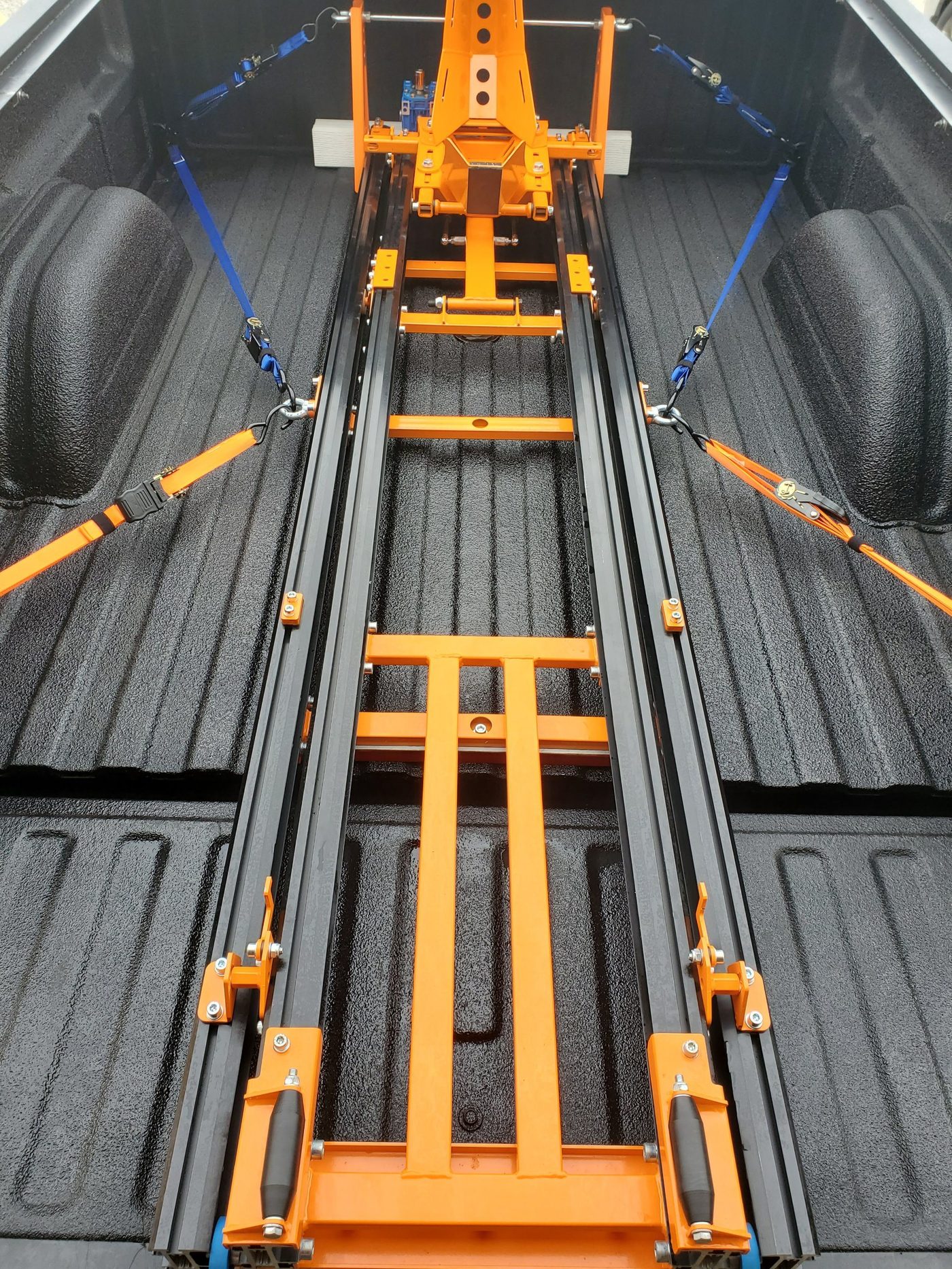 Neo-Dyne ramp mounted in a pickup bed with the AC-012 no-drill kit and ratchet straps