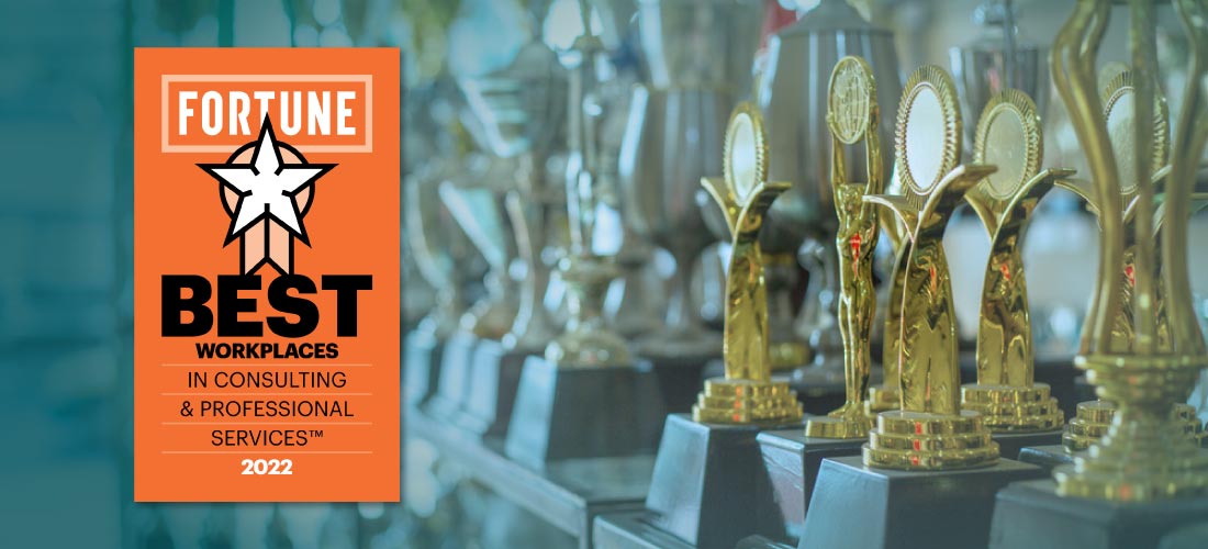 A close-up view of a shelf filled with awards and trophies and to the left, a badge with the Fortune logo and a star emblem that reads: Best Workplaces in Consulting & Professional Services 2022