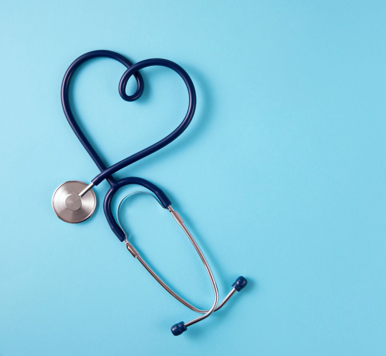 a stethoscope is shaped into a heart on a blue background