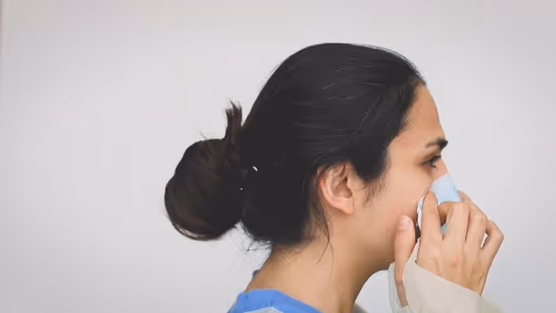 Woman fitting medical mask to nose