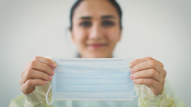 woman holding protective face mask open