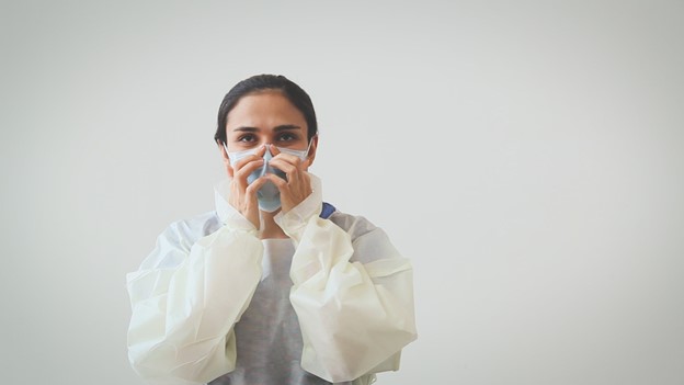 woman ensuring proper fit of mask across nose bridge by pressing