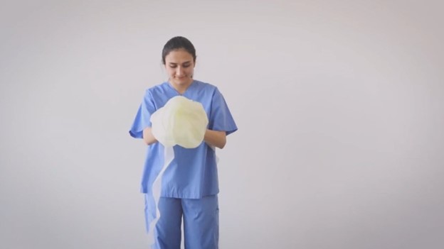 rolling up open back gown for disposal