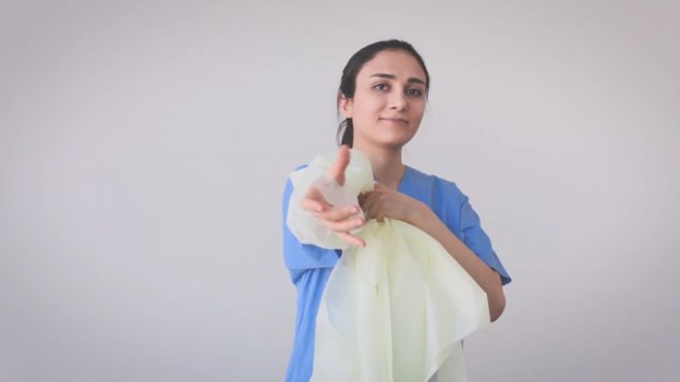 Donning single-use overhead open back thumbloop gown