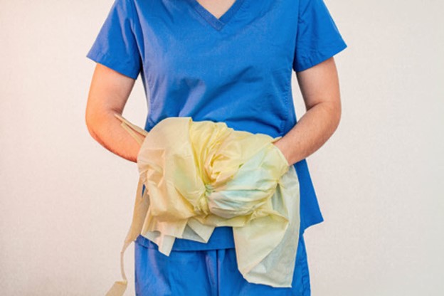 Proper doffing of gown with contaminated surfaces on inside