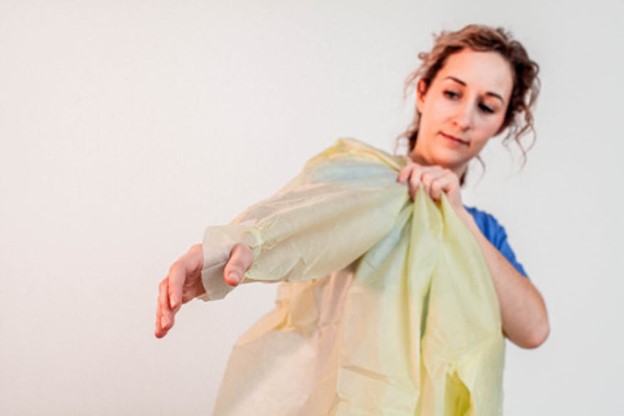 tie back gown donning putting arms in sleeves