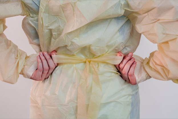 Donning tie gown at waist