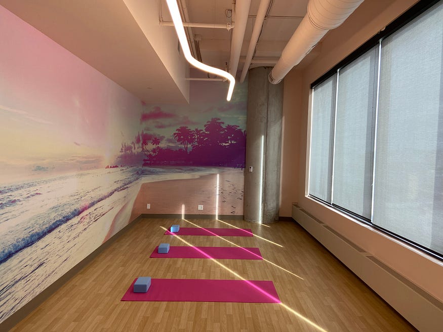 Yoga room with serpentine fluorescent light fixture hanging from ceiling.