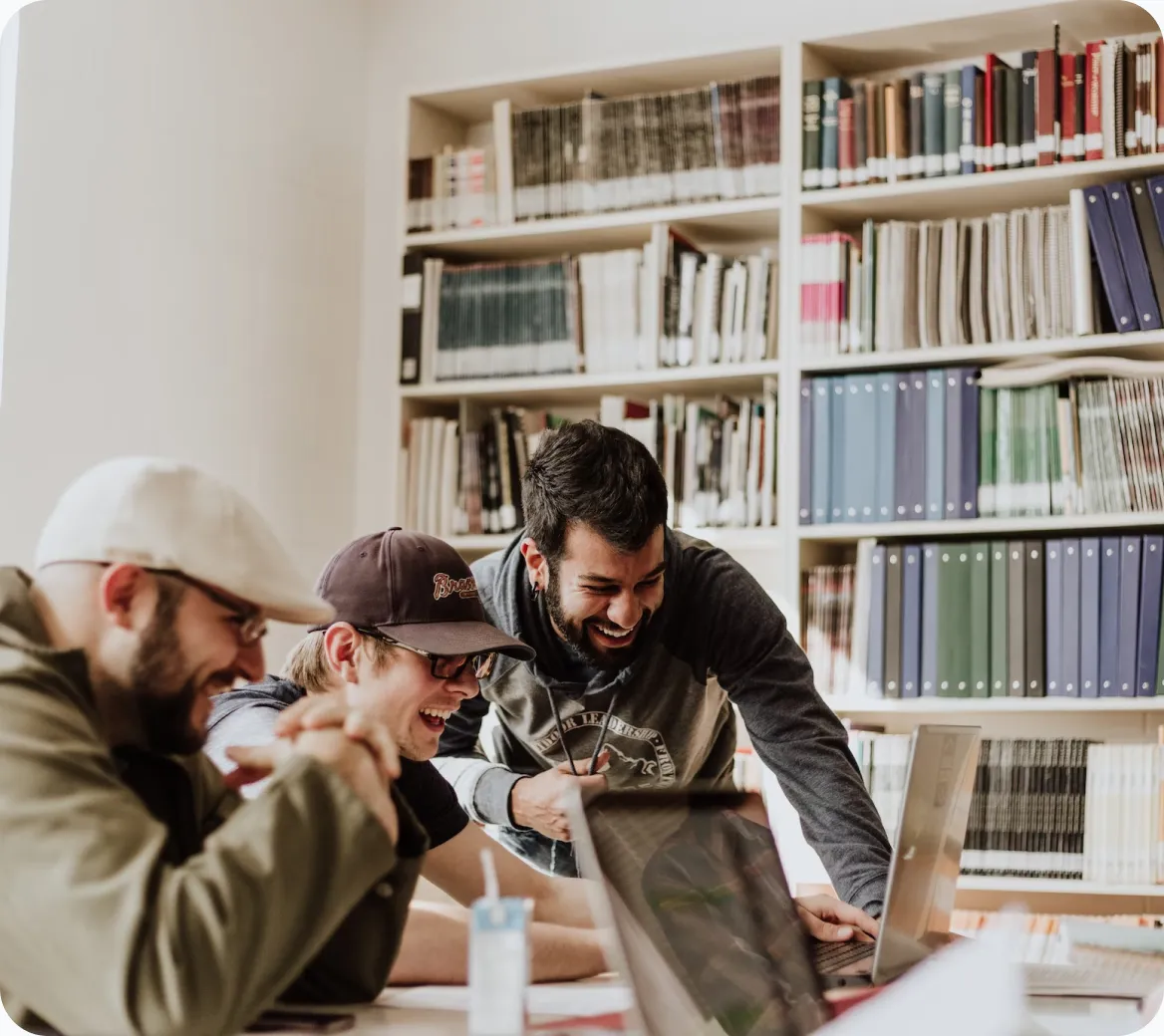 a group of men looking at a laptop
