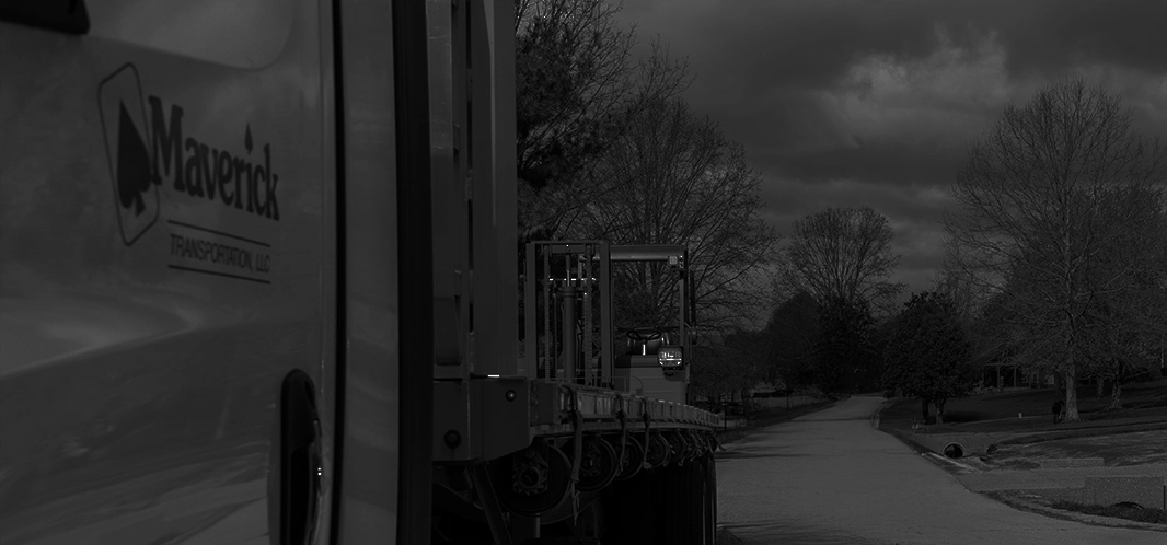 A Maverick Dedicated tractor trailer with a long driveway behind it