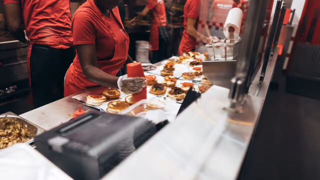 Fast food workers building burgers and preparing orders