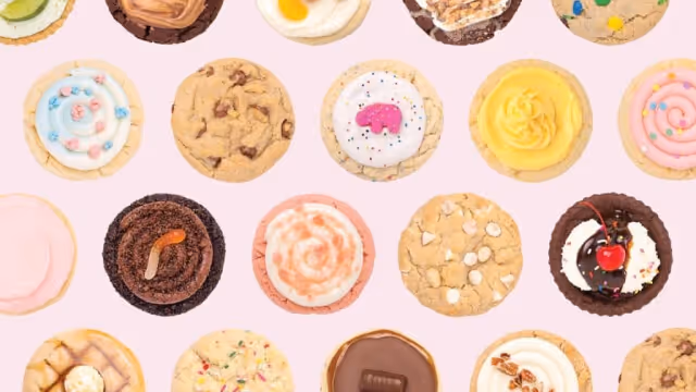 A bunch of different favoured Crumbl cookies on a pink backdrop