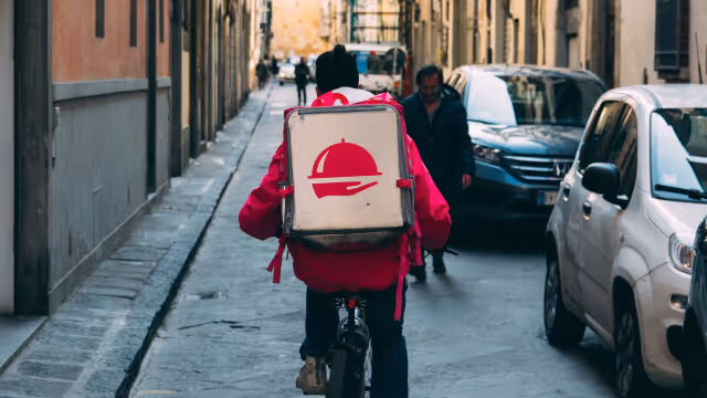Biker with a delivery thermal bag on his back