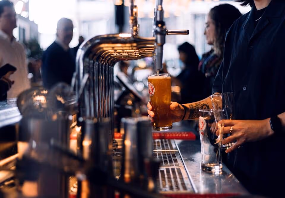 Inside crowded pub with bartender pouring beer
