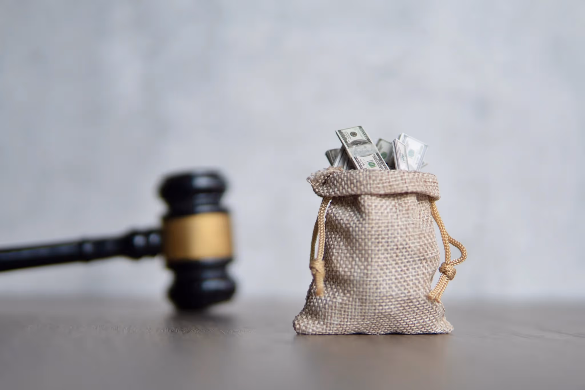 Gavel and bag of money on a table for a sex abuse lawsuit settlement