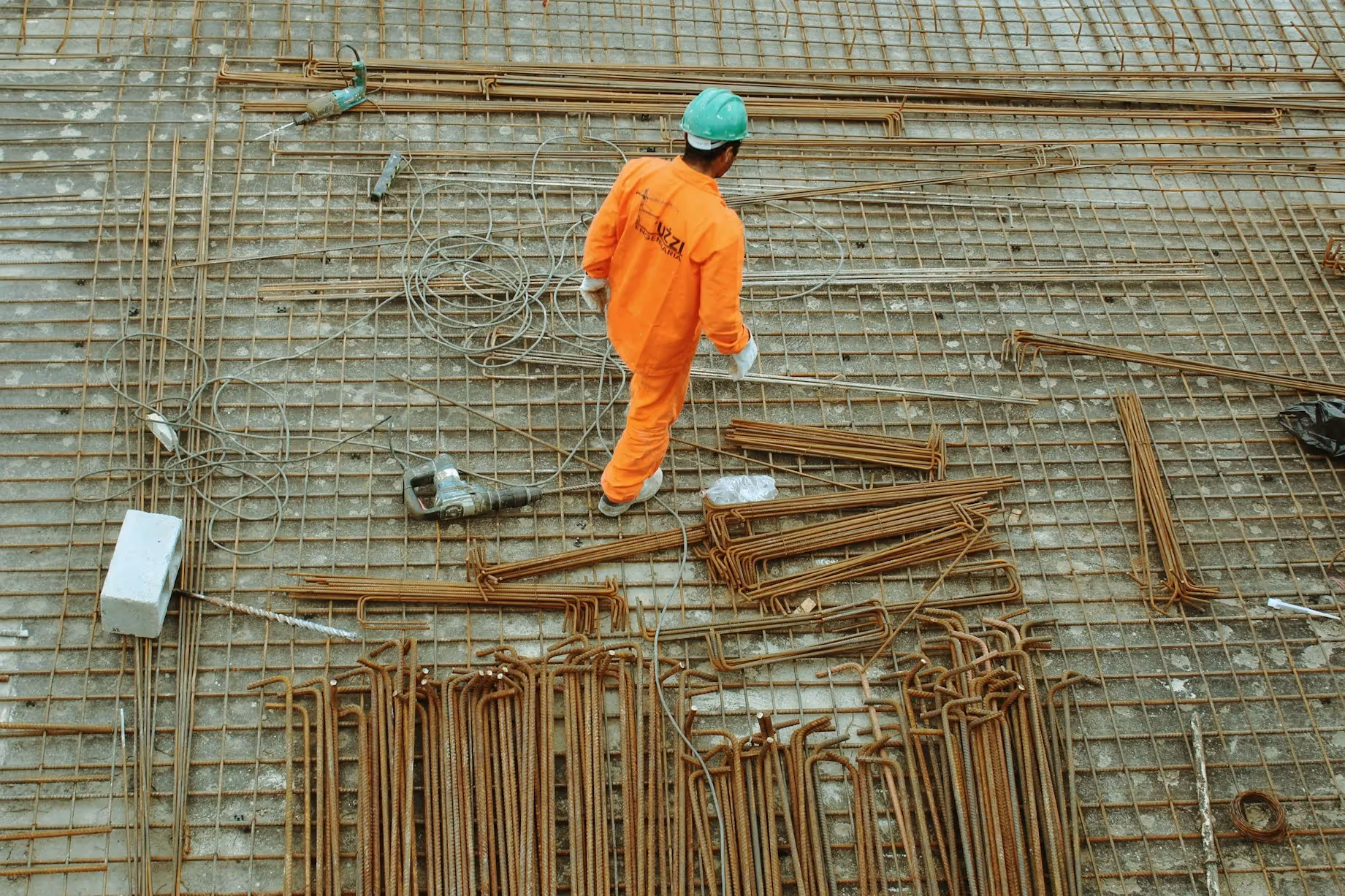 Construction worker in orange safety gear at a building site