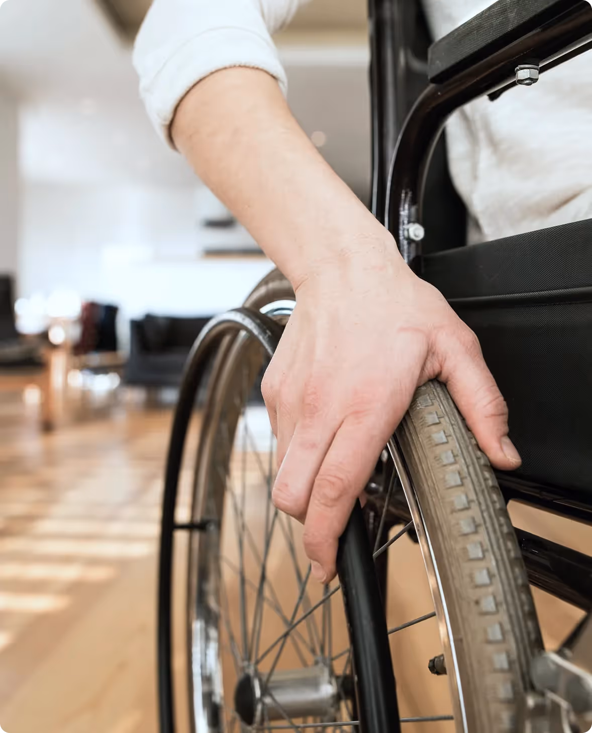 Person in a wheelchair gripping the wheel after a spinal cord injury