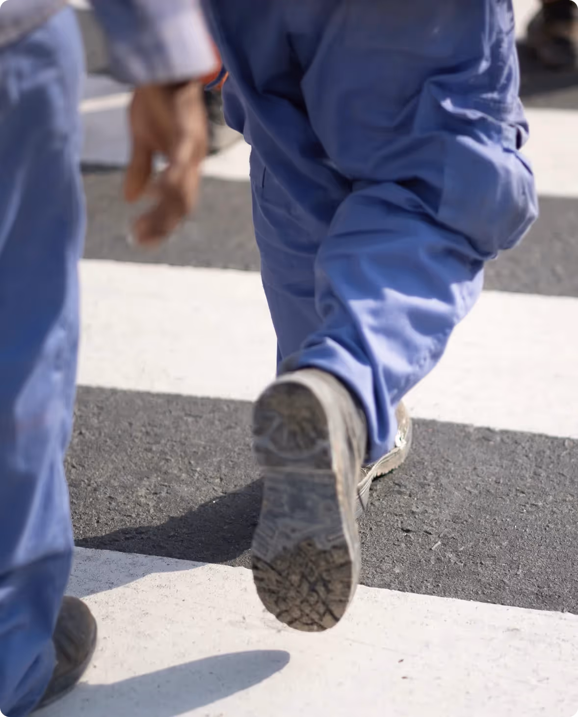 Pedestrians in blue clothing crossing a city intersection