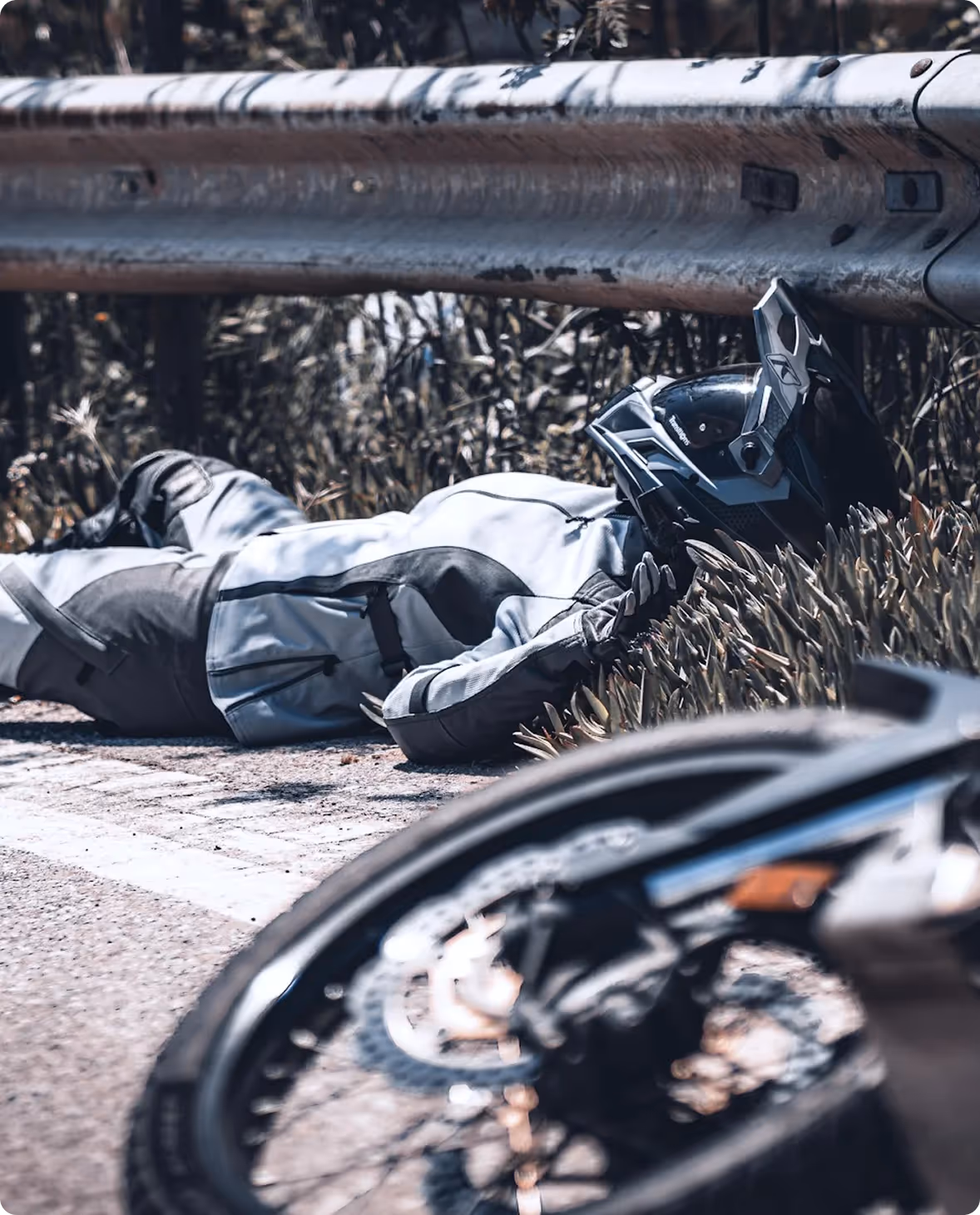 Motorcyclist lying on the highway beside a crashed motorcycle