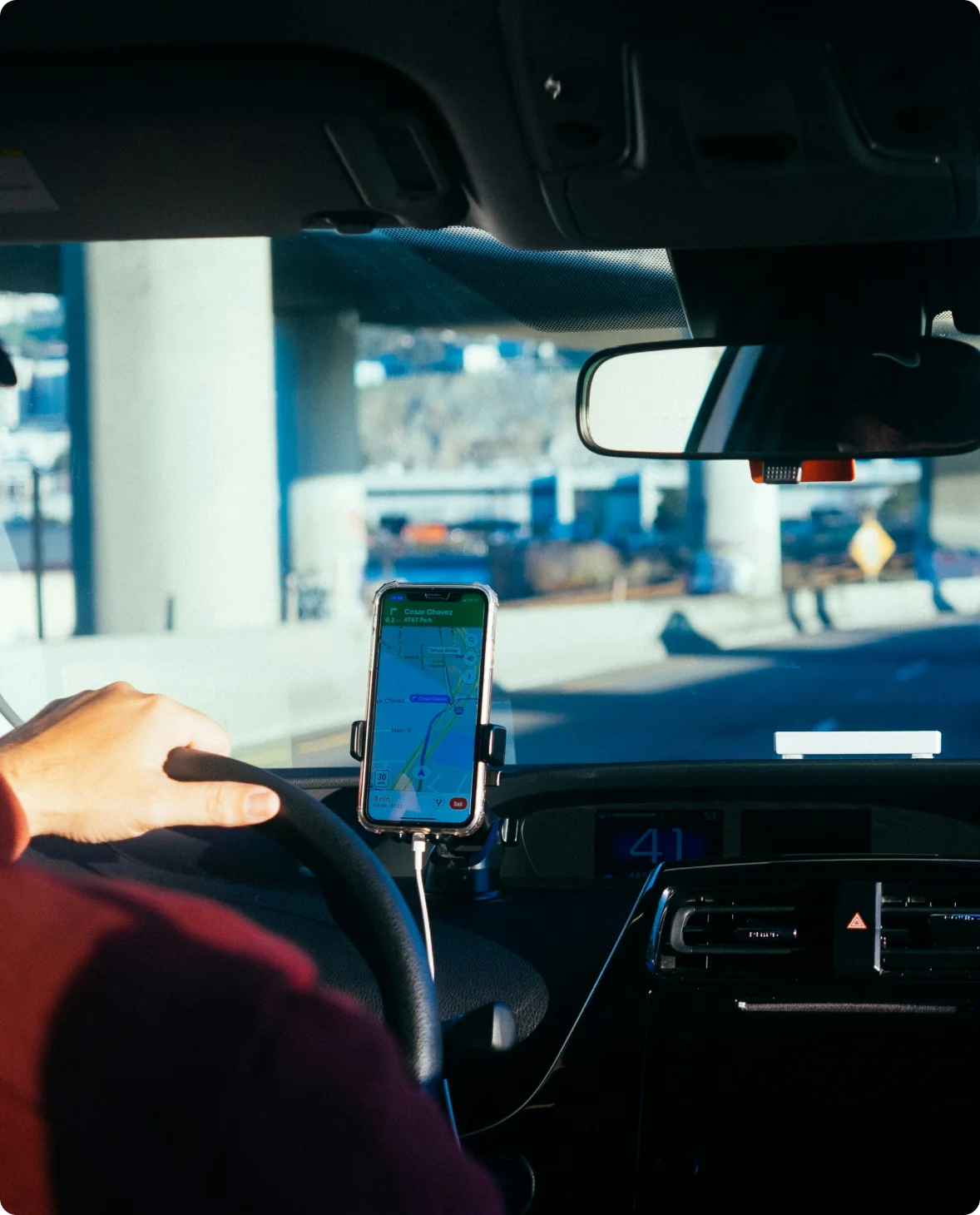 Rideshare driver using phone navigation while taking a passenger to their destination