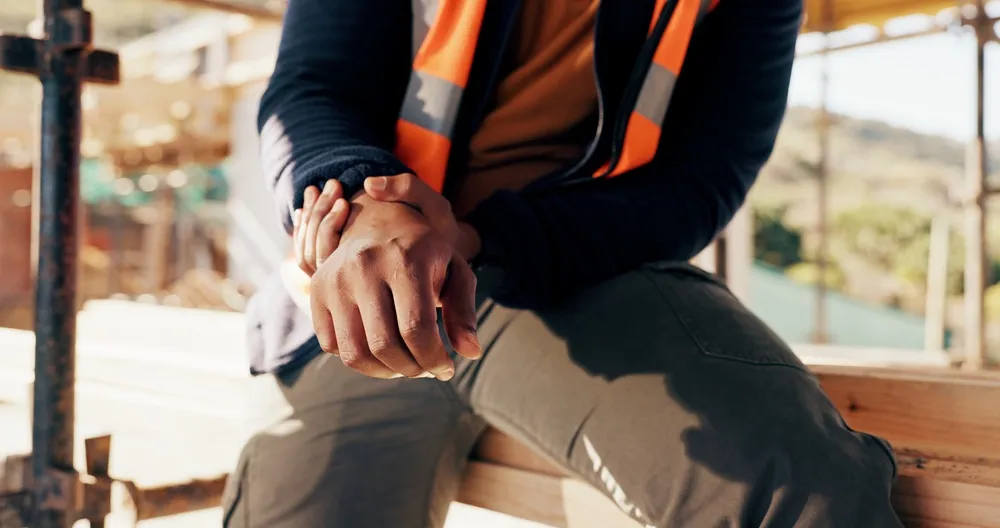 Injured construction worker holding his wrist at a job site in Atlanta