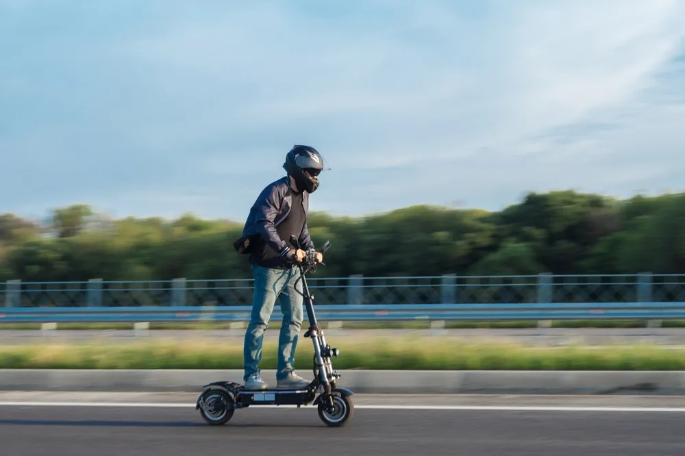 Person riding an electric scooter on a California road