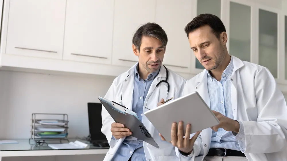 Doctors reviewing medical records for a pre-existing condition