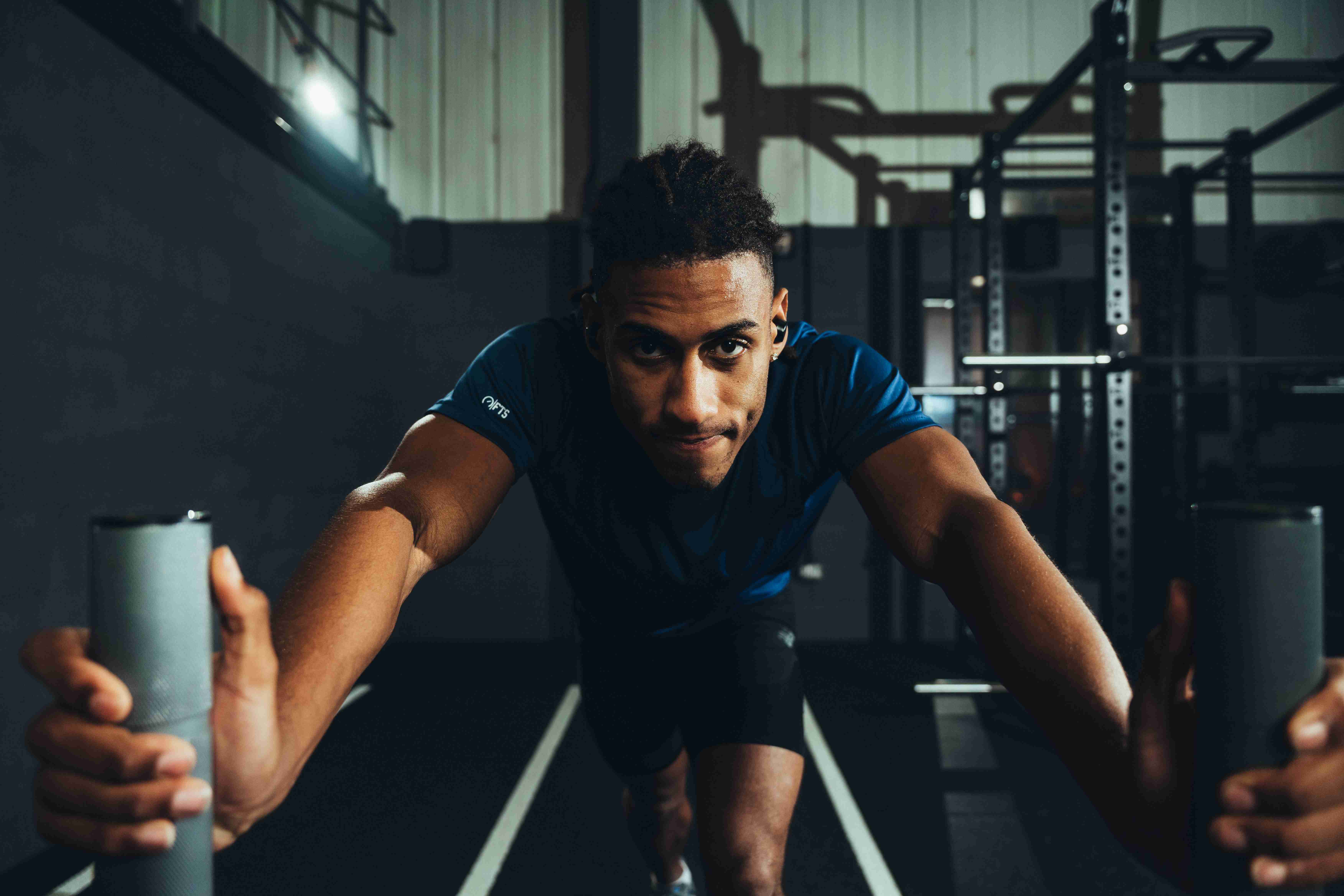 Athlete pushing weighted sled during a HYROX training plan session