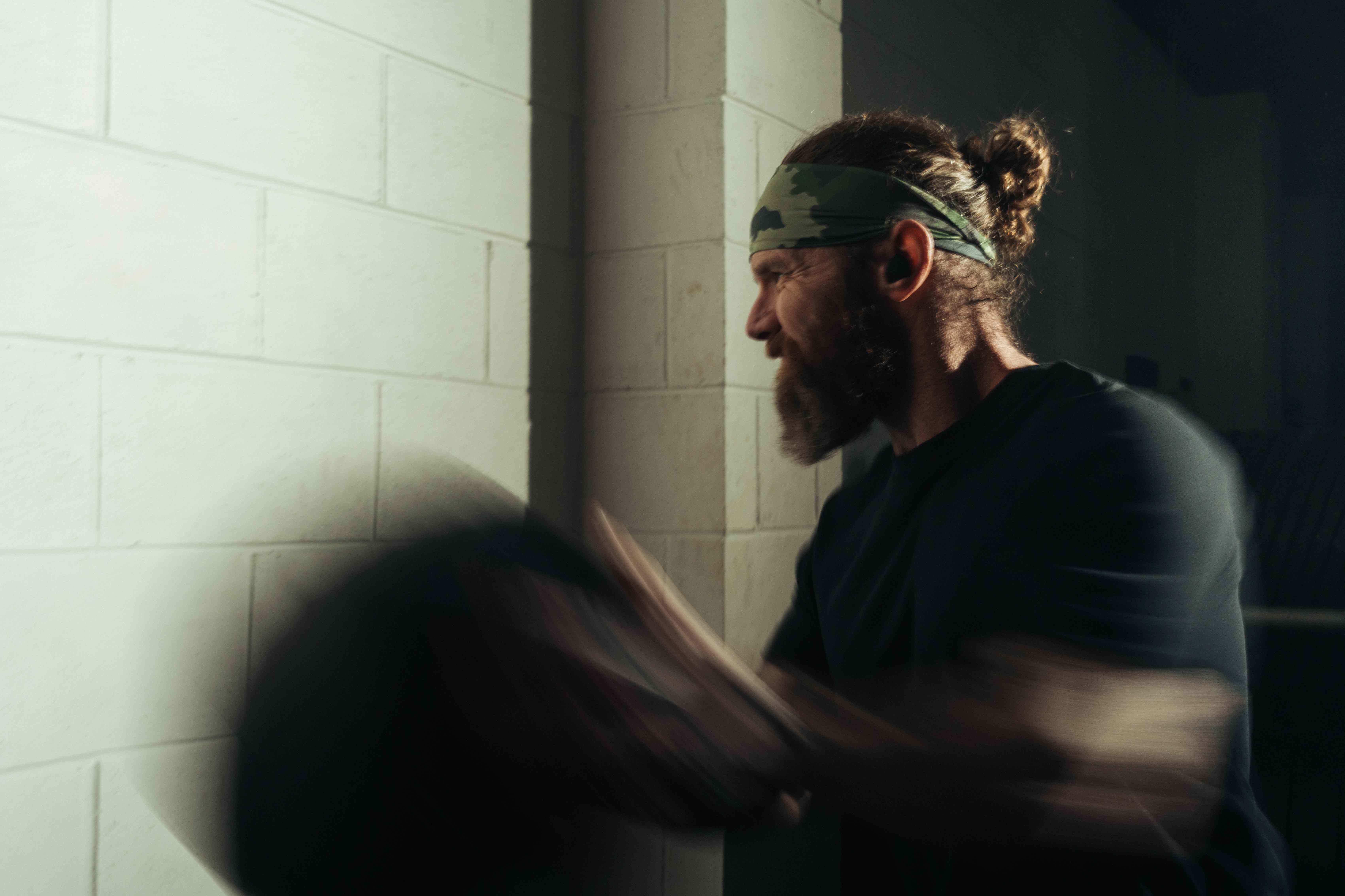 Athlete training to the best music for HYROX training during a wall ball station with offline workout earbuds