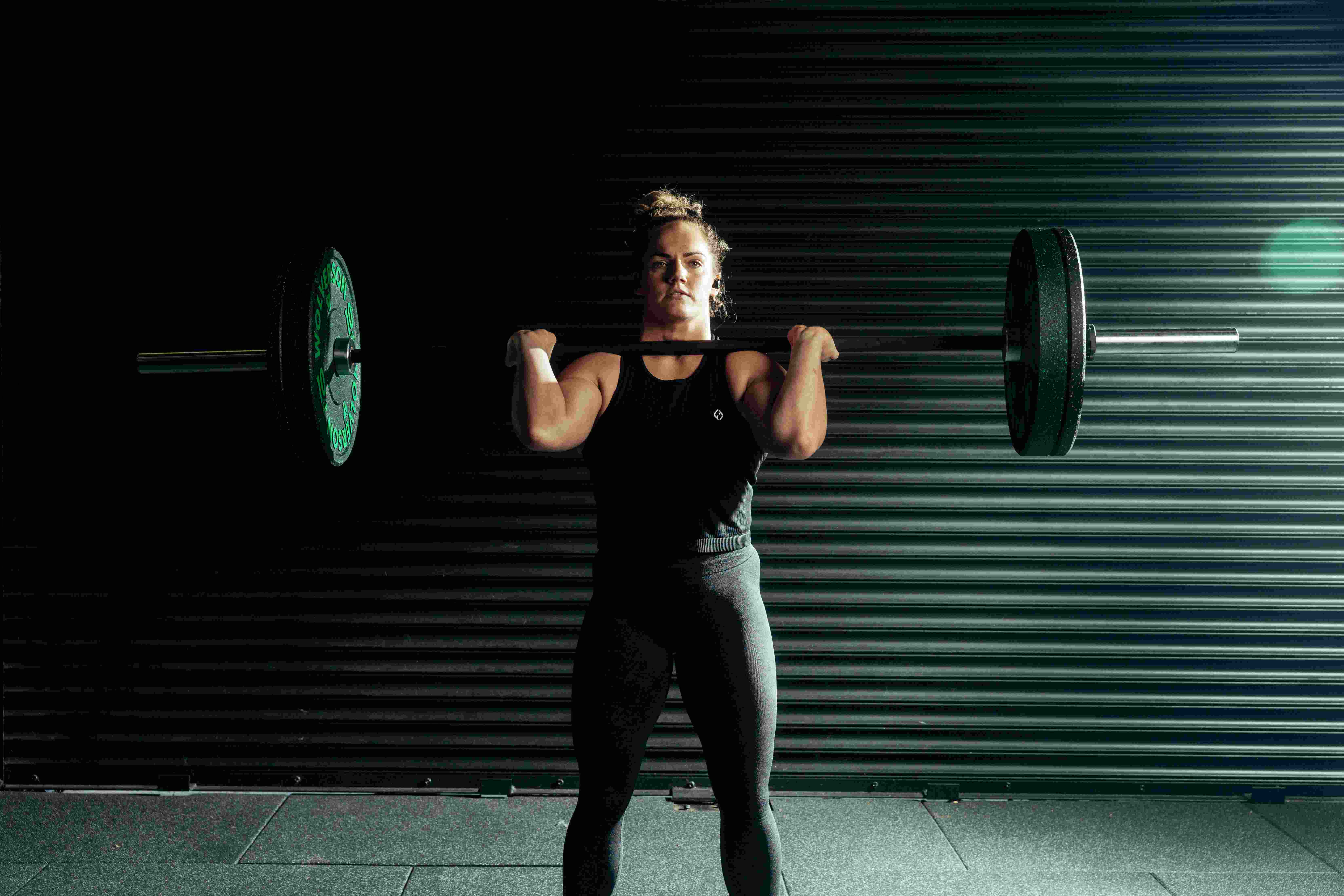 Hybrid athlete training with a weighted sled push during a HYROX-style functional fitness workout