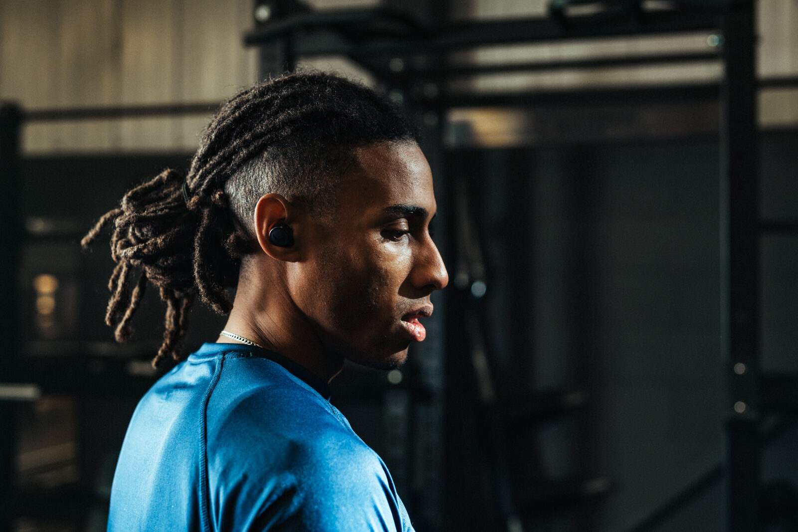 Side profile of an athlete showing in-ear earbud fit against the concha