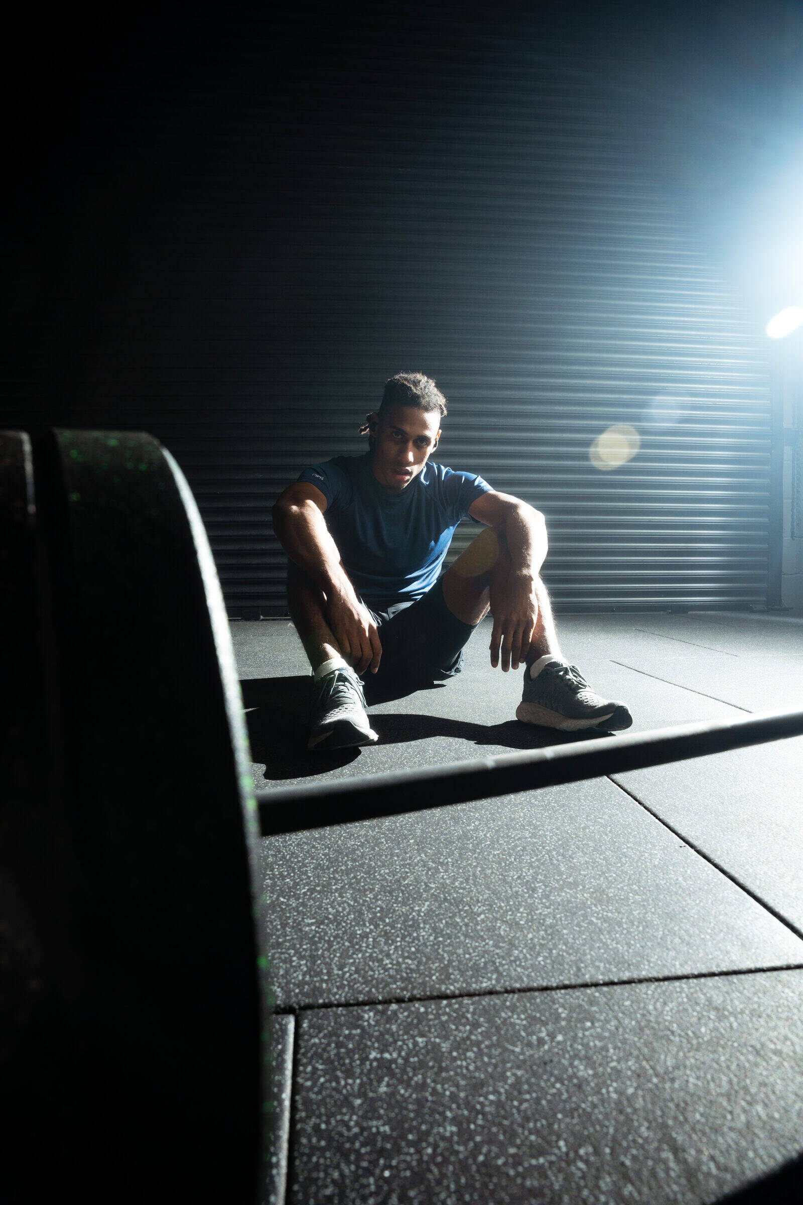 Athlete resting between sets with no phone in sight, wearing Tzuka TZ7 Ultra earbuds