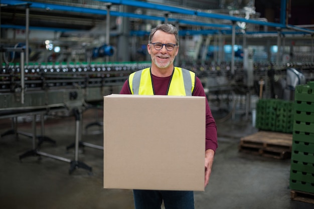 Portrait factory worker holding cardboard box