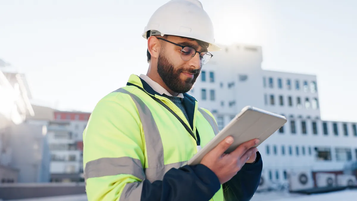 Workplace risk assessment example: engineer checking site conditions on a tablet at a customer site