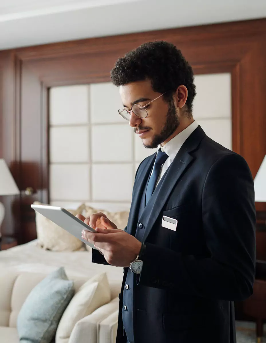 Young hotel manager in a hotel room looking at a tablet