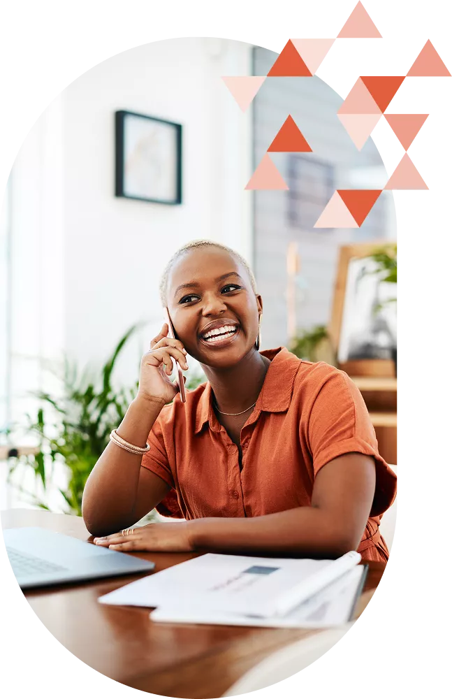 Black young businesswoman with reports in front of her talking on the phone 