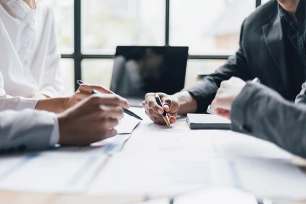 equipe em reunião analisando documentação da empresa