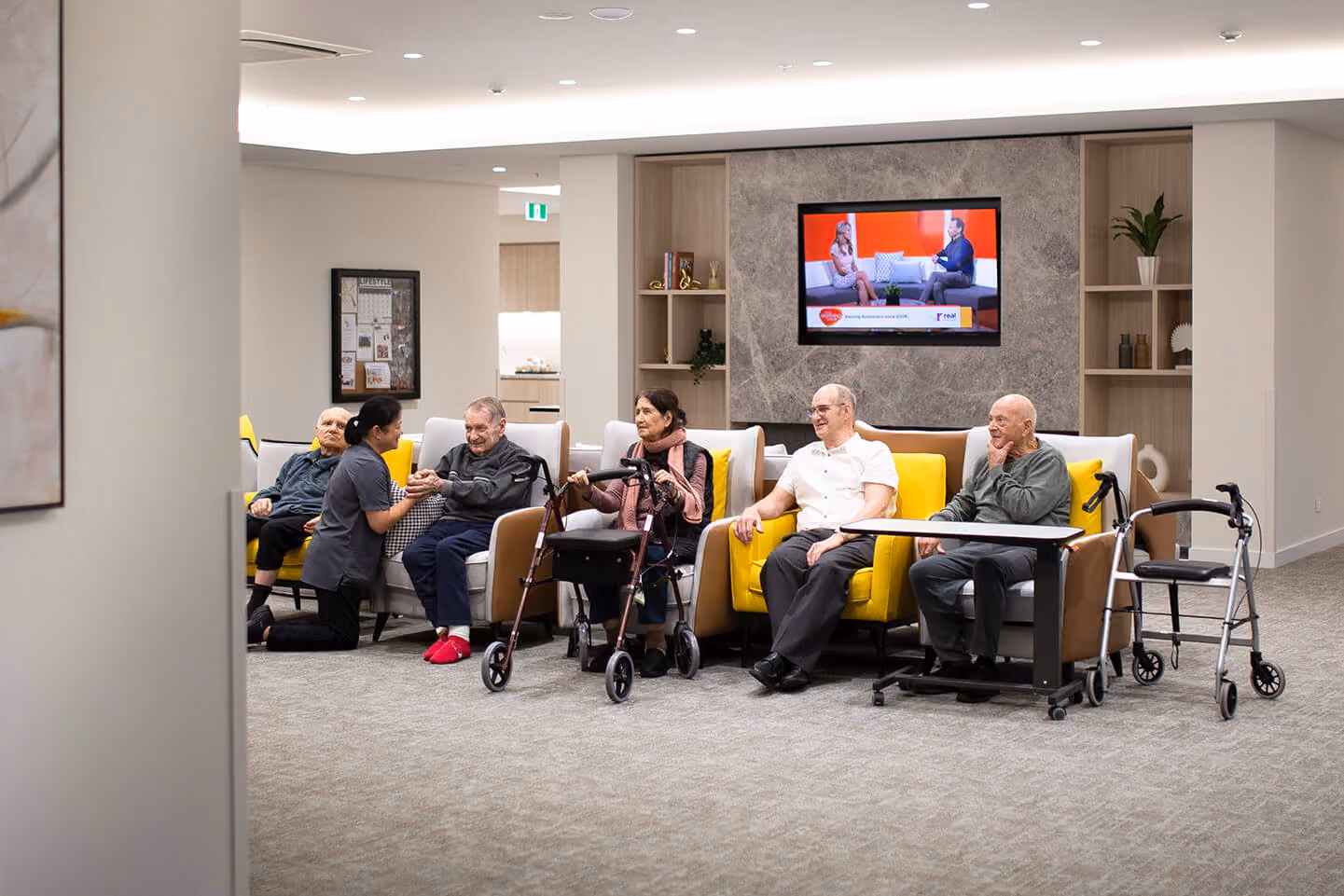 Oxa Care residents relaxing together with a team member in a shared lounge area.