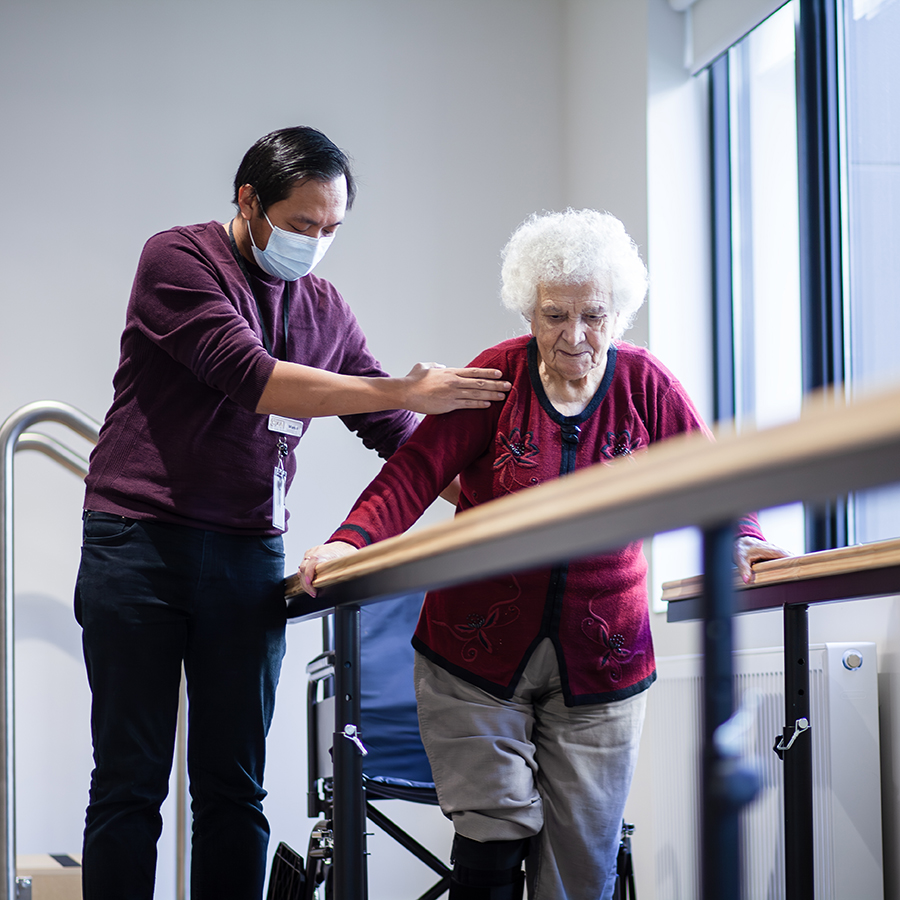 Oxa Care team member supporting a resident during a walking and mobility exercise.