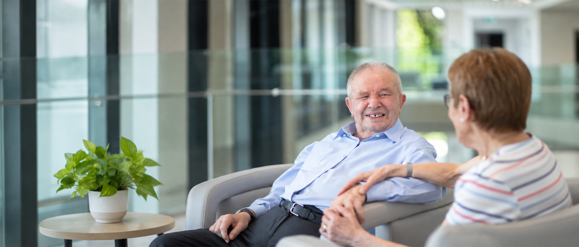 Oxa Care resident chatting with a companion in a comfortable lounge area.